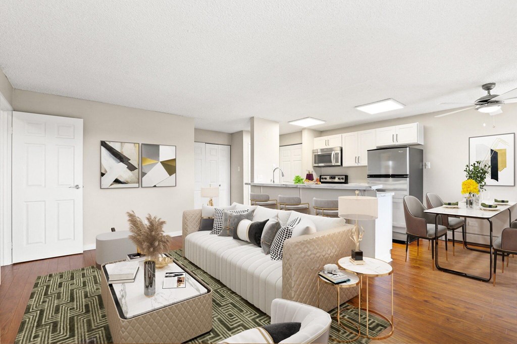 A modern living room with a white sofa and a glass coffee table  at 4805 E Kentucky in Denver, CO