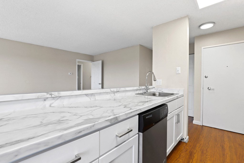 A kitchen with a marble countertop and white cabinets  at 4805 E Kentucky in Denver, CO