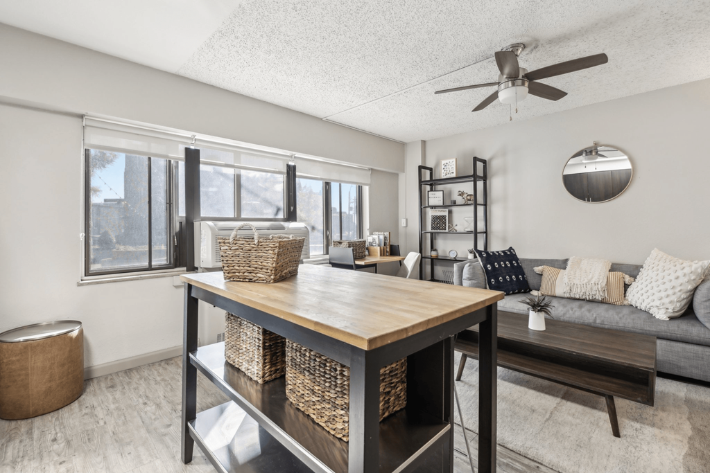 an open living room and dining room with a table and a ceiling fan at Archer Tower in Denver, CO