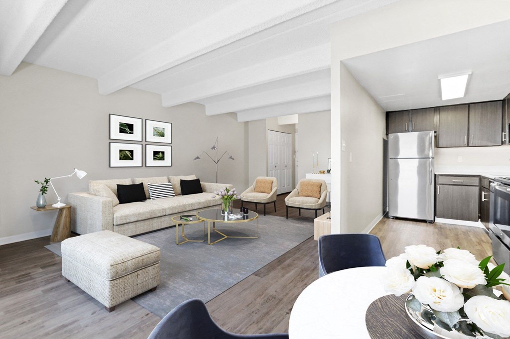 A modern living room with a white couch, a grey ottoman, a coffee table, and a dining table with chairs at 878 S Dexter St in Denver, CO