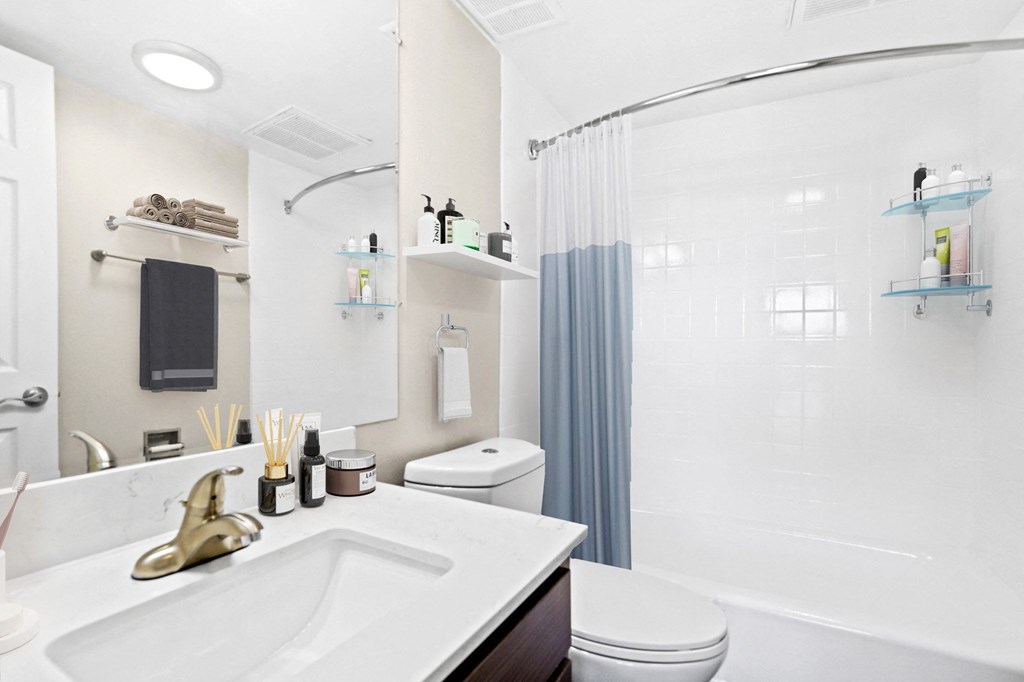 A white bathroom with a white sink and a white toilet.