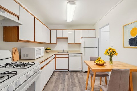 A kitchen with a white gas stove and a white refrigerator.