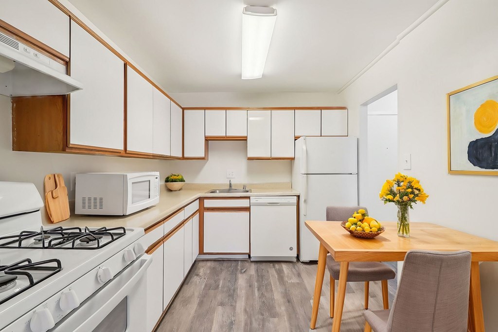 A kitchen with a white gas stove and a white refrigerator.