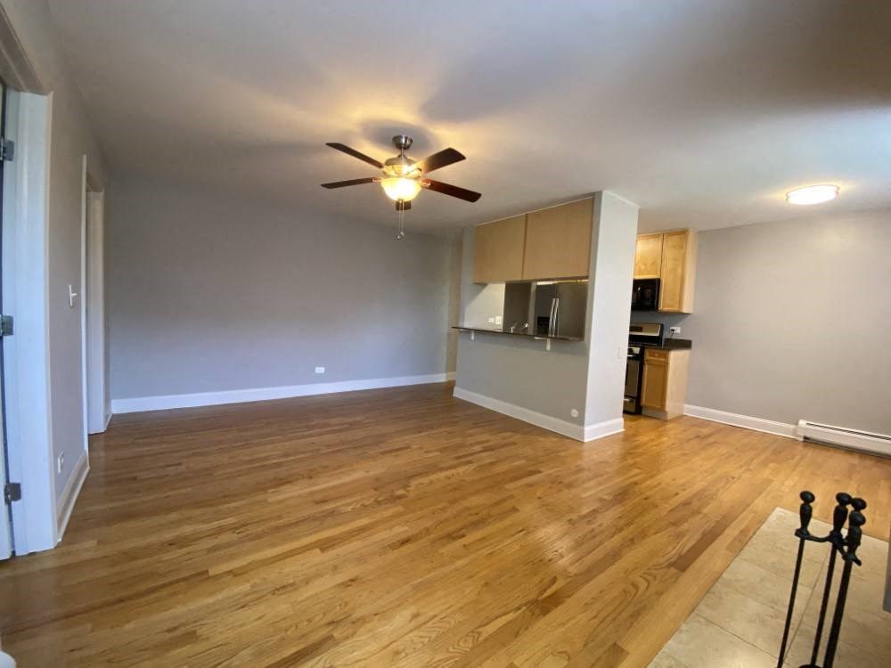 Nice hardwood flooring and a ceiling fan in the living area - Two Bedroom