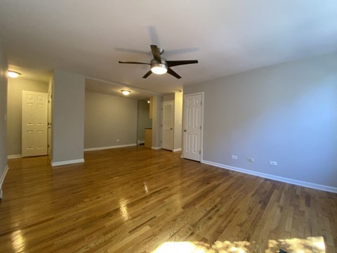 a living room with wood floors and a ceiling fan