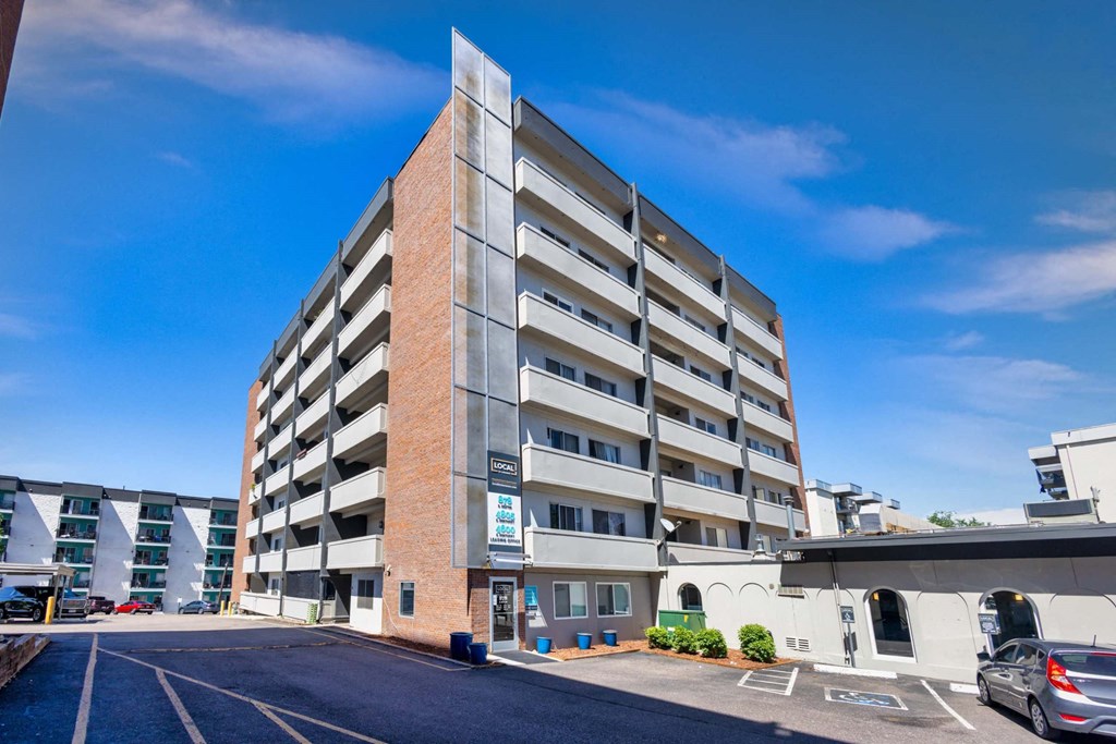 A large multi-story parking garage with a car parked in the foreground at 878 S Dexter St in Denver, CO
