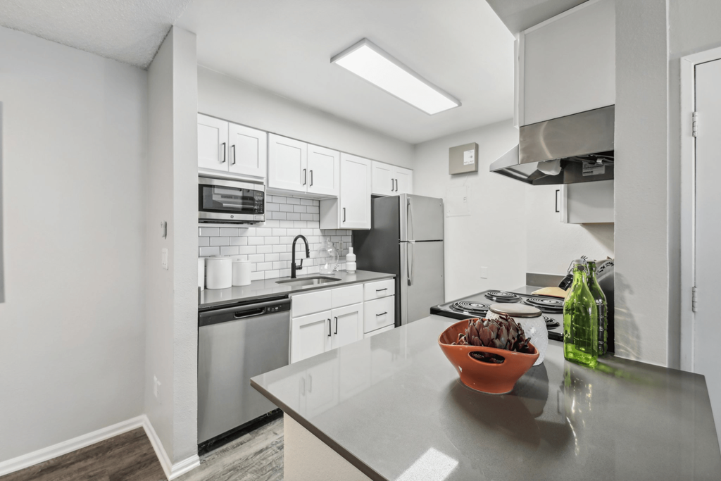 A kitchen with a bowl of fruit on the counter.