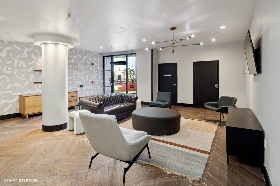 a living room with a couch and chairs and a tv