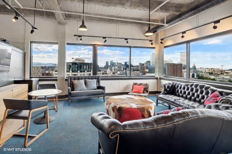 a living room with leather furniture and a view of the city