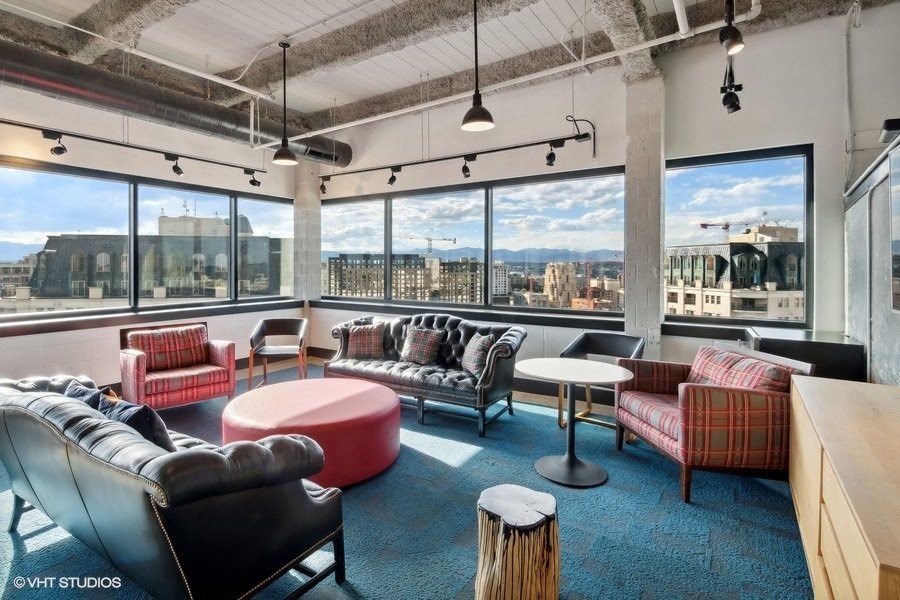 a living room with couches and chairs and a view of the city