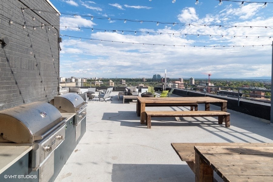 the roof terrace with picnic tables and a view of the city