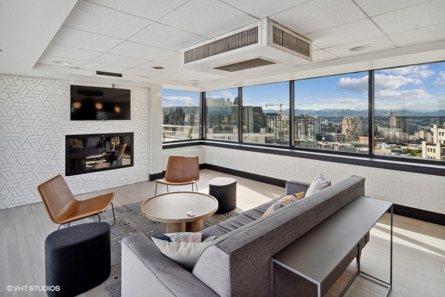 a living room with a couch and a fireplace and a view of the city