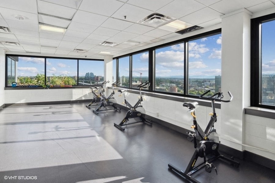 a workout room with a view of the city