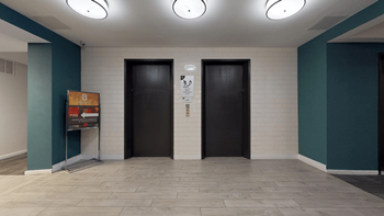 two black doors in a room with a tile floor and blue walls