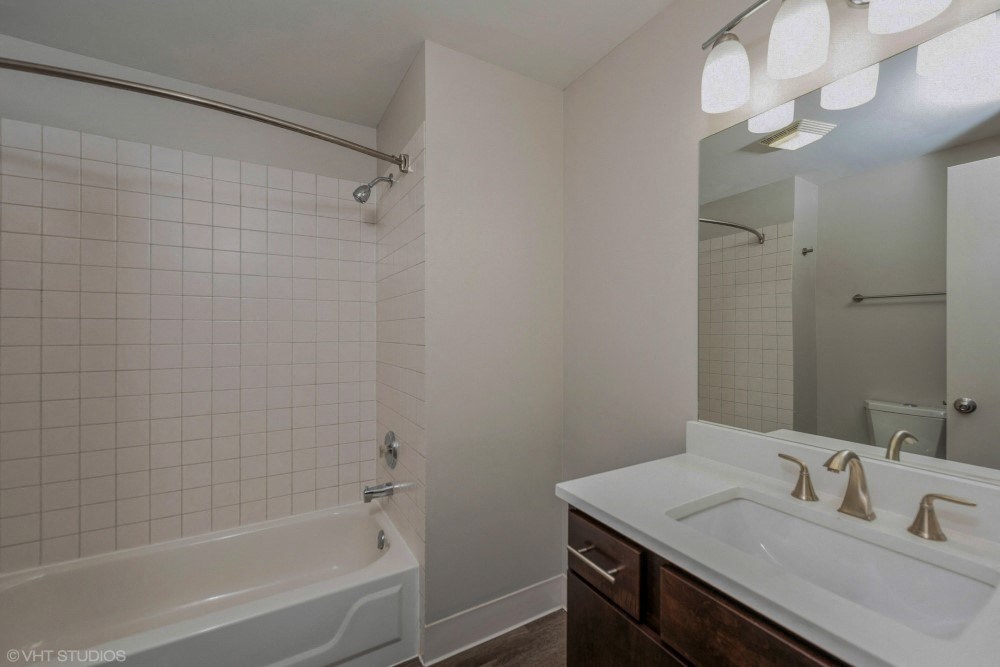 Bathroom with vanity storage and a full tub at Carriage House Lofts, Illinois