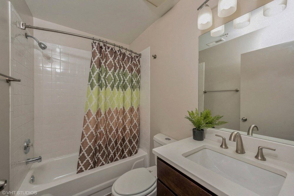 Bathroom with vanity storage and a full tub at Carriage House Lofts, Chicago