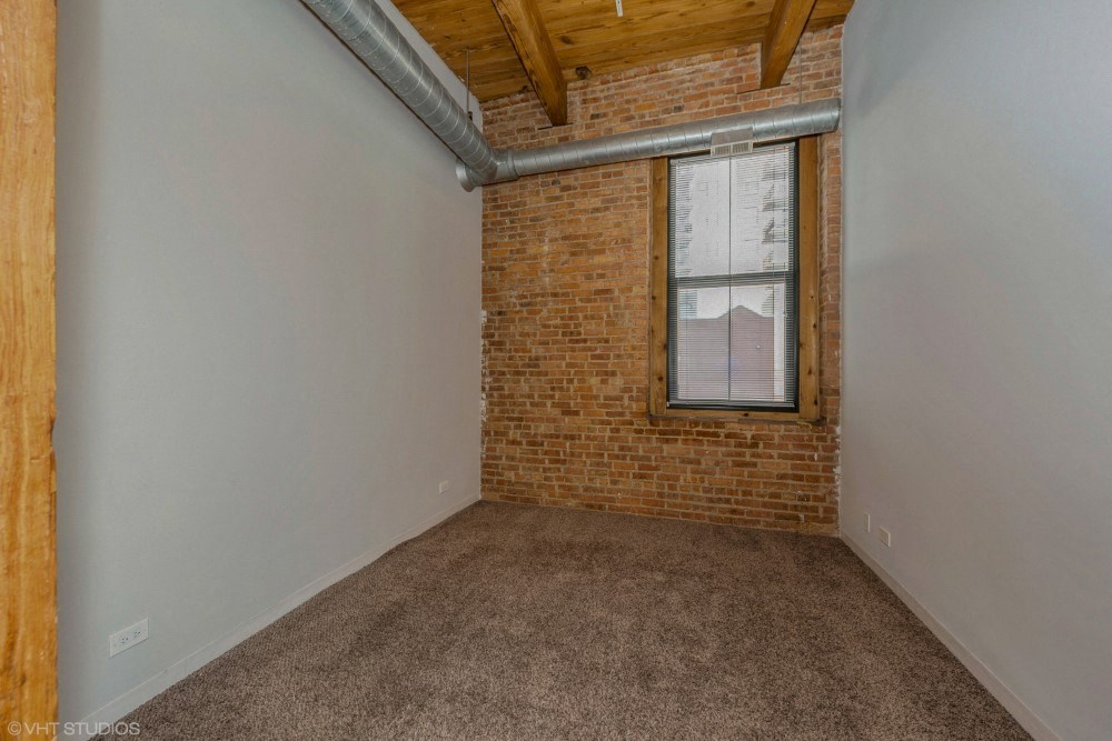Bedroom with exposed brick wall at Carriage House Lofts, Chicago, IL, 60605