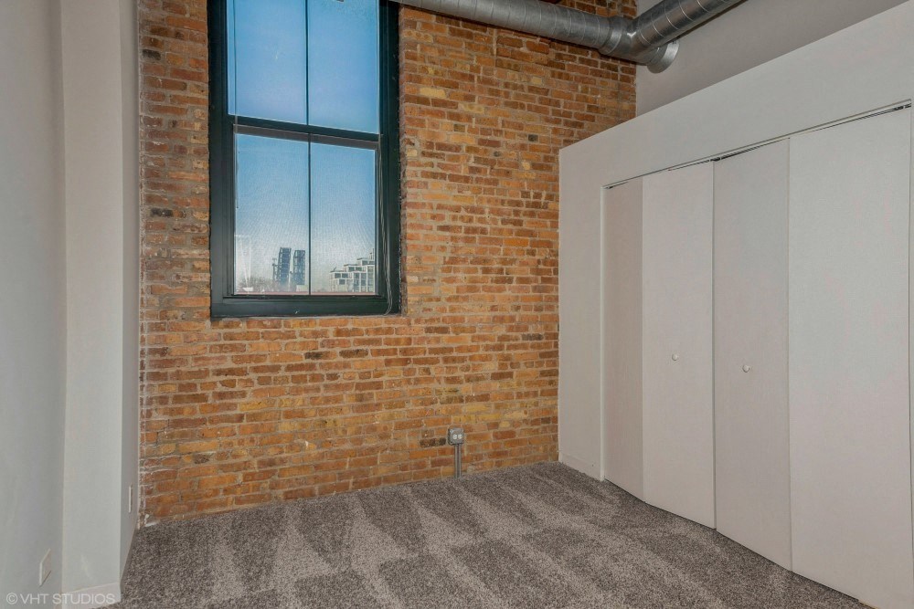 Bedroom with closet space and plush carpeting at Carriage House Lofts, Chicago, IL