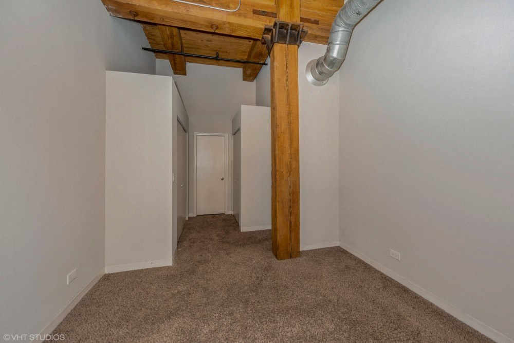 Bedroom with wood beams and high ceilings at Carriage House Lofts, Illinois, 60605