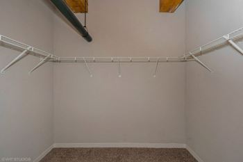 the spacious closet in the master bedroom of a home with white walls