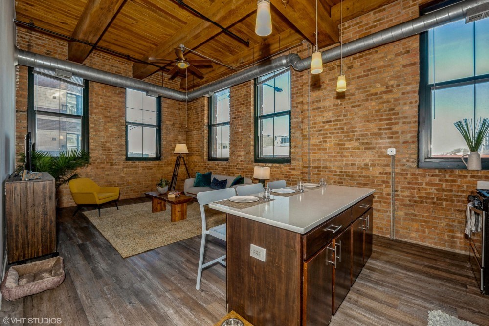 Open living area with a ceiling fan and lovely city views at Carriage House Lofts, Chicago