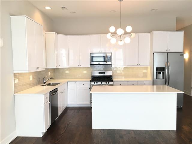 A modern kitchen with white cabinets and a central island.