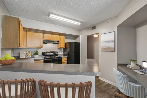 A kitchen with wooden cabinets and a grey countertop.