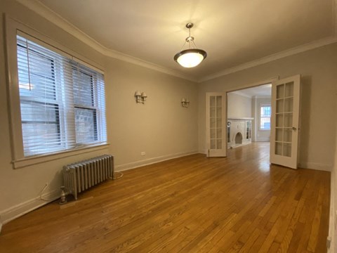the living room and dining room of a house with wood floors and a large window