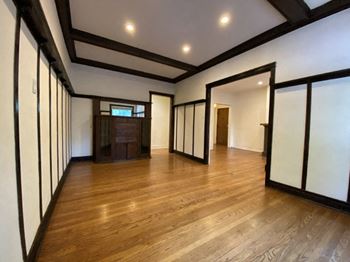 A room with wooden floors and white walls with black trim.