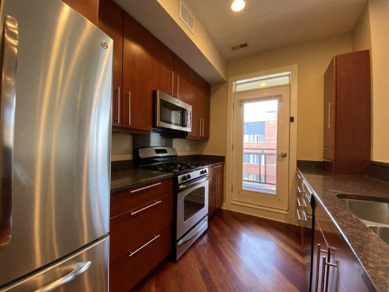 Large kitchen featuring granite countertops, dishwasher, microwave and stainless steel appliances