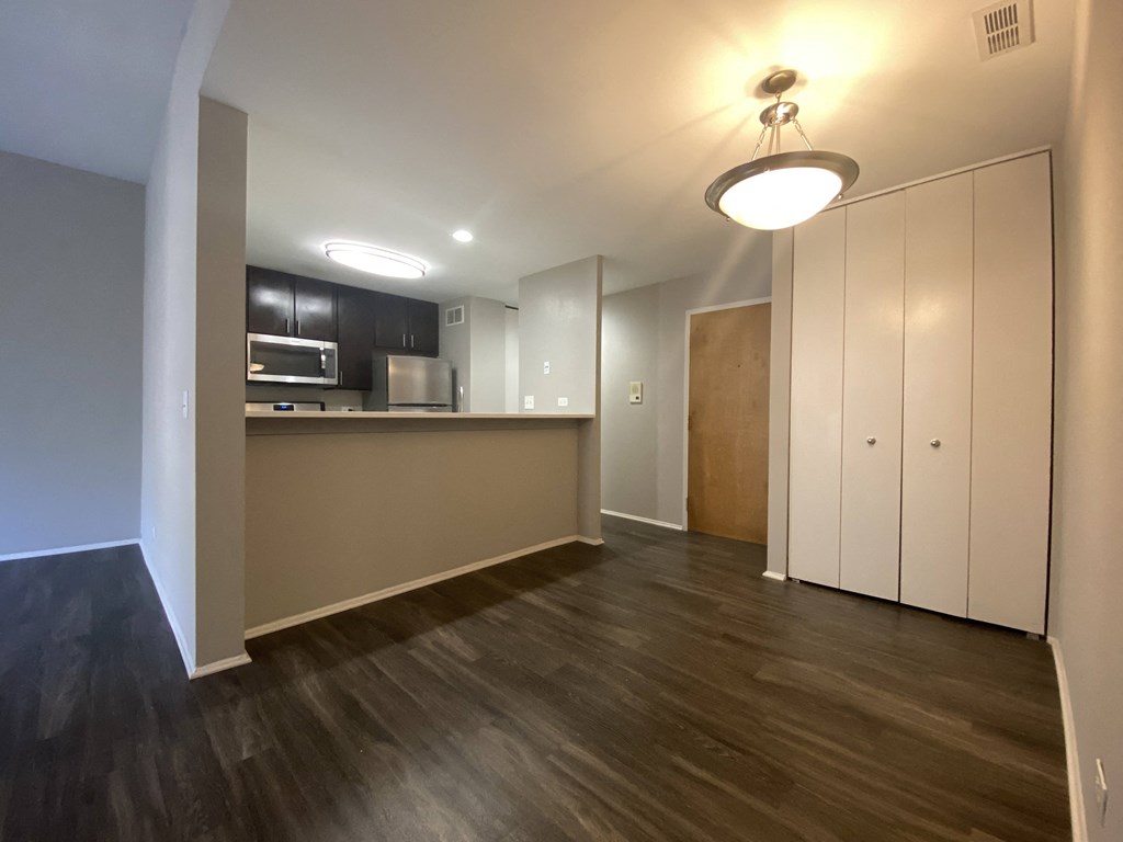 Open kitchen with rich flooring and stainless steel appliances