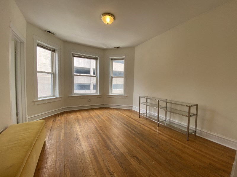 Spacious living space with genuine hardwood floors and large windows