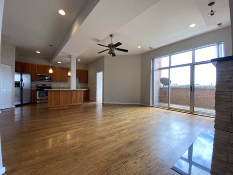 A spacious living room with a ceiling fan and sliding glass doors.