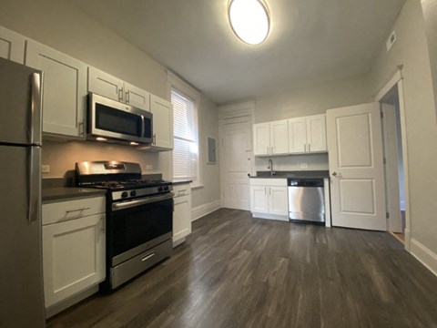 A kitchen with white cabinets and a black stove top oven.