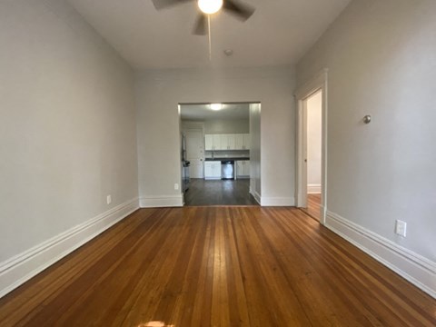 A room with wooden floors and a ceiling fan.