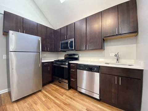 A kitchen with wooden cabinets and stainless steel appliances.