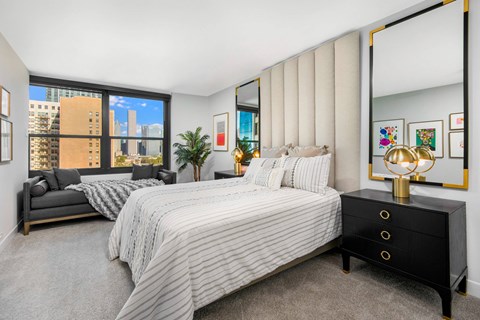 A bedroom with a large bed and a view of the city.