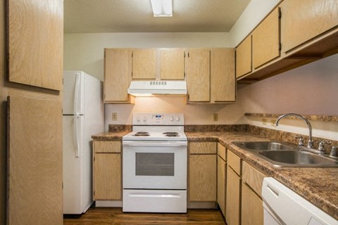 A kitchen with wooden cabinets and white appliances.