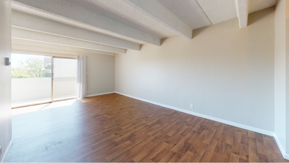 Bright living space with floor to ceiling windows and balcony access