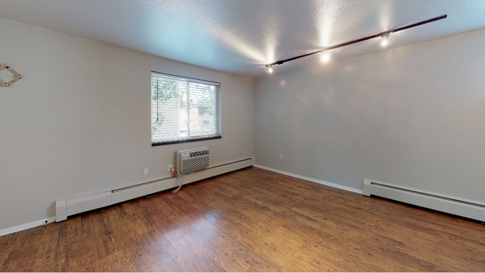 Bright living space with track lighting and hardwood floors
