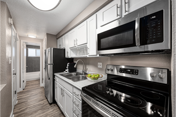 a kitchen with stainless steel appliances and white cabinets