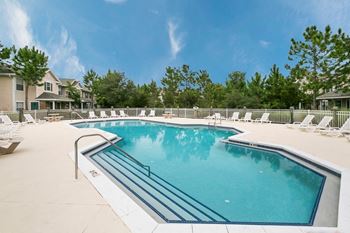 A large swimming pool with a metal ladder and a metal hand rail.