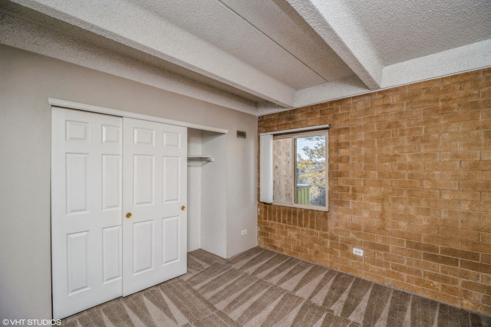 Bedroom with a large closet and plush carpeting