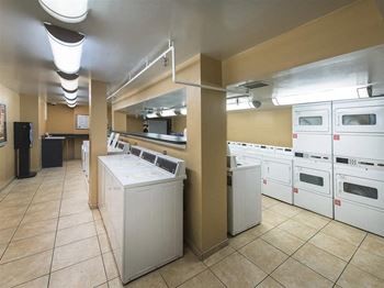Laundry Center with Machines Next to Folding Counter at Trillium Apartments, Virginia, 22031