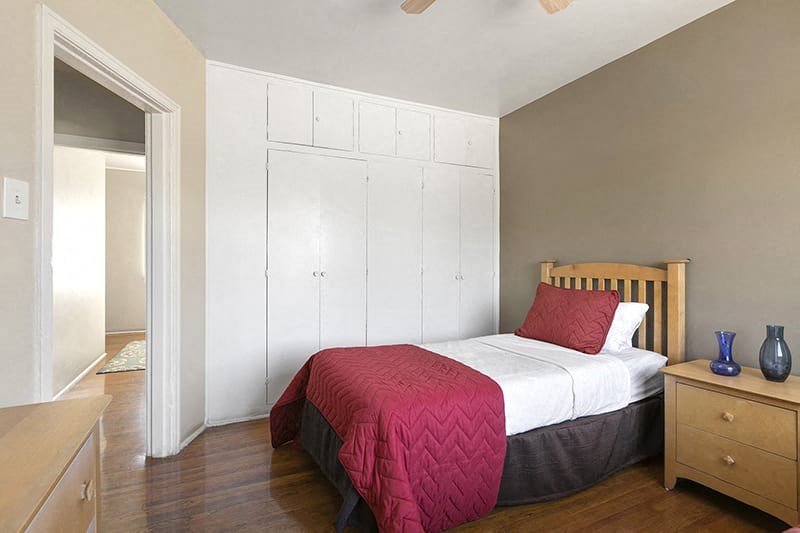 a bedroom with a bed with a red blanket