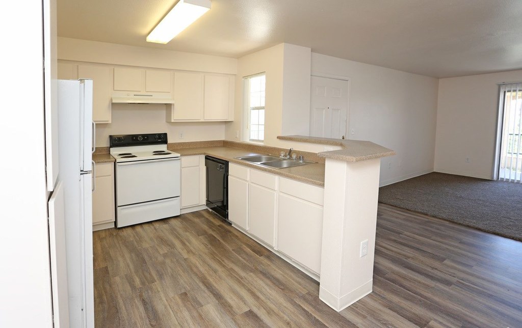 Open kitchen with white appliances at Canon de Arrowhead in Albuquerque, New Mexico