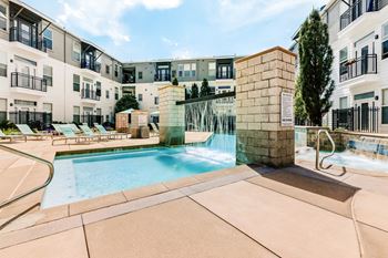 our apartments offer a swimming pool with a waterfall and lounge chairs