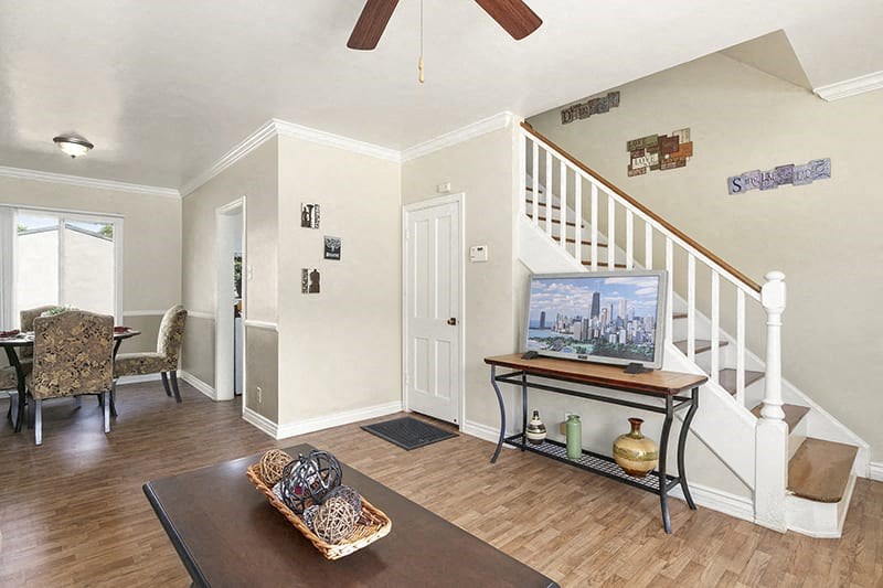 a living room with a television and a staircase
