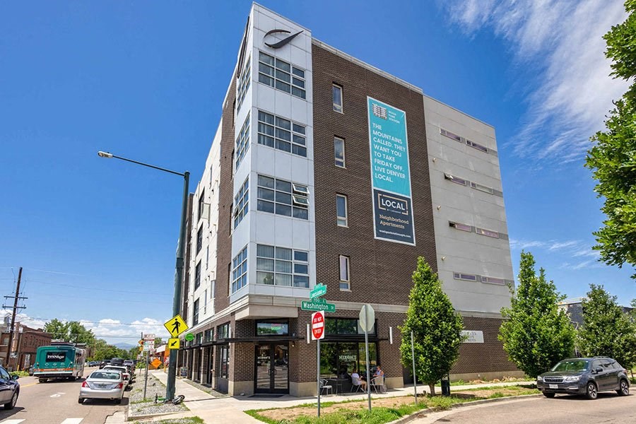 A street view of a building with a sign that says  at Wash Park Station in Denver, CO