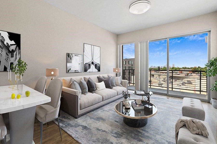 A modern living room with a large window overlooking a balcony.
